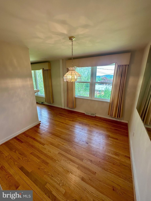 2475 Wharton Rd, York, PA 17402 - unfurnished dining area featuring wood finished floors and a chandelier