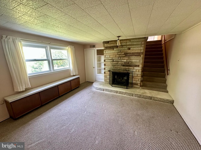 2475 Wharton Rd, York, PA 17402 - unfurnished living room with a fireplace, light carpet, and stairway