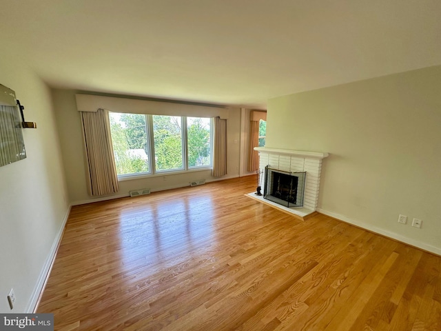 2475 Wharton Rd, York, PA 17402 - unfurnished living room with wood finished floors and a brick fireplace