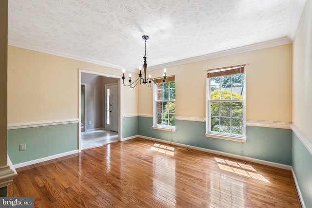 16715 Tintagel Ct, Dumfries, VA 22025 - unfurnished room with a chandelier, a textured ceiling, wood finished floors, and ornamental molding