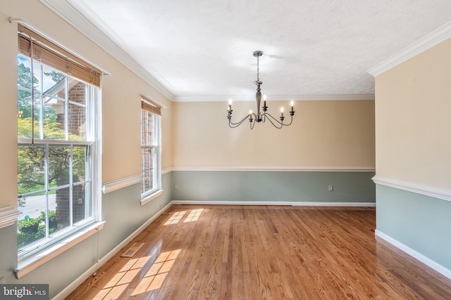 16715 Tintagel Ct, Dumfries, VA 22025 - empty room with a chandelier, wood finished floors, ornamental molding, and a textured ceiling