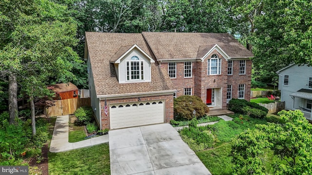 16715 Tintagel Ct, Dumfries, VA 22025 - view of front facade with brick siding, driveway, an attached garage, and a shingled roof