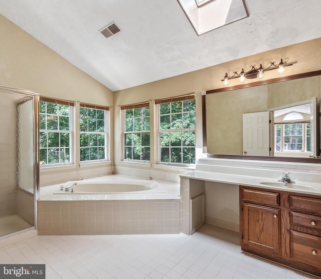 16715 Tintagel Ct, Dumfries, VA 22025 - bathroom featuring tile patterned flooring, vanity, a garden tub, healthy amount of natural light, and vaulted ceiling