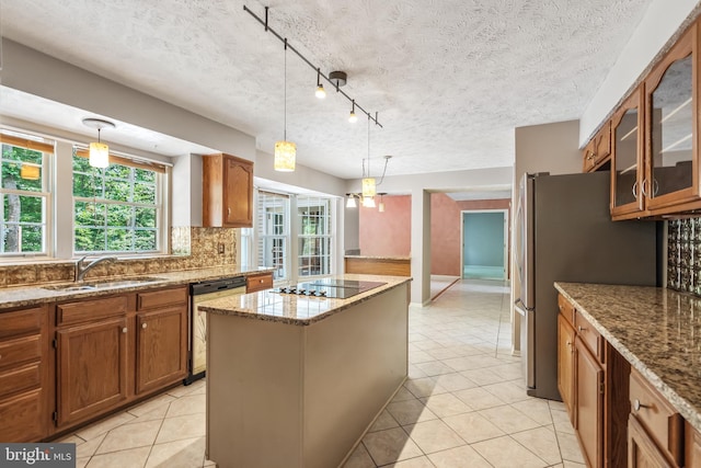 16715 Tintagel Ct, Dumfries, VA 22025 - kitchen featuring stainless steel appliances, brown cabinetry, a center island, decorative backsplash, and light tile patterned floors