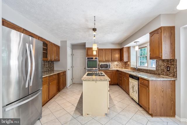 16715 Tintagel Ct, Dumfries, VA 22025 - kitchen with appliances with stainless steel finishes, a center island, backsplash, brown cabinetry, and decorative light fixtures