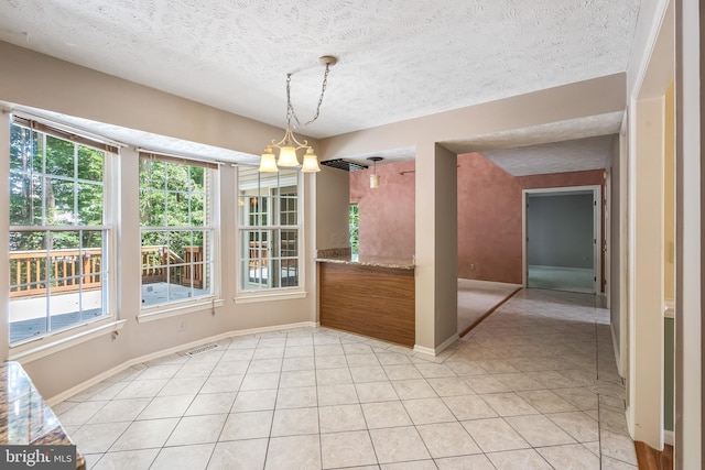 16715 Tintagel Ct, Dumfries, VA 22025 - unfurnished dining area with plenty of natural light, a textured ceiling, a chandelier, and light tile patterned floors