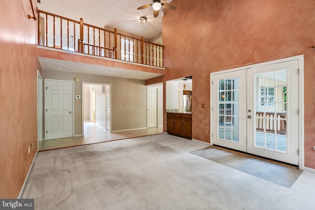 16715 Tintagel Ct, Dumfries, VA 22025 - unfurnished living room featuring french doors, a ceiling fan, a high ceiling, and carpet flooring
