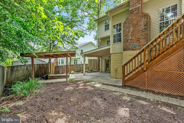 16715 Tintagel Ct, Dumfries, VA 22025 - rear view of house featuring brick siding, a patio, a fenced backyard, and stairs