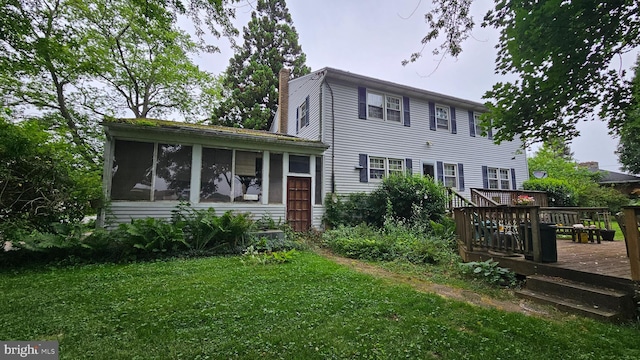 59 Singer Rd, New Freedom, PA 17349 - rear view of house with a sunroom, a wooden deck, a chimney, and a lawn