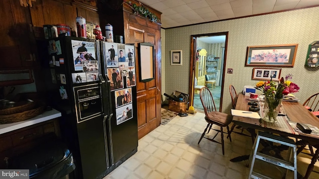 59 Singer Rd, New Freedom, PA 17349 - kitchen with black fridge, light floors, ornamental molding, light countertops, and wallpapered walls
