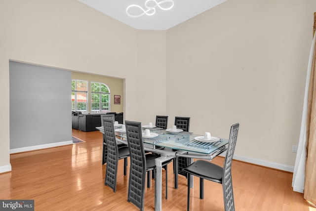 13716 Molly Berry Rd, Brandywine, MD 20613 - dining area featuring light wood-style flooring, a chandelier, and a towering ceiling