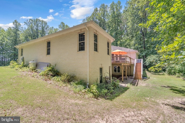 13716 Molly Berry Rd, Brandywine, MD 20613 - view of property exterior featuring stairs, a deck, brick siding, and a lawn