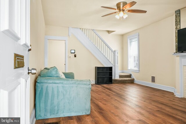 2929 N W St, Wilmington, DE 19802 - living room featuring stairs, wood finished floors, a ceiling fan, and a fireplace