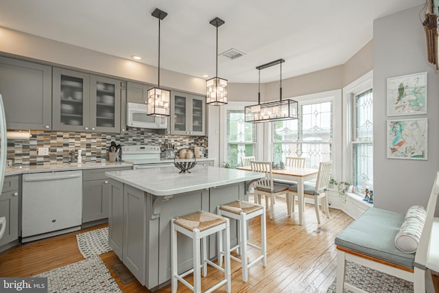 151 N Union St Unit 6, Lambertville, NJ 08530 - kitchen featuring gray cabinets, white appliances, tasteful backsplash, wood-type flooring, and a breakfast bar