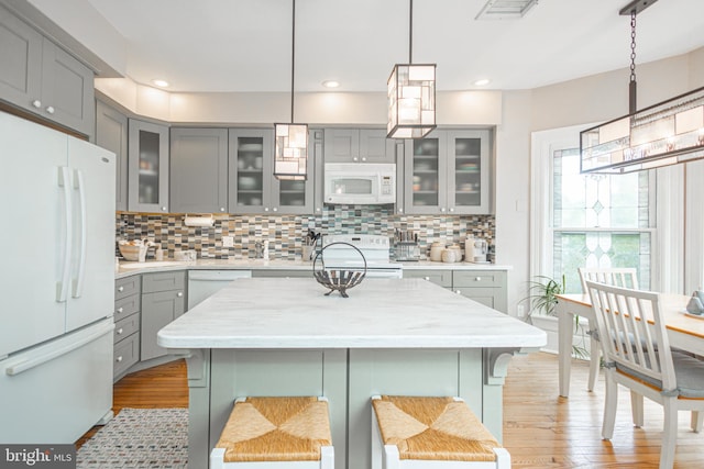 151 N Union St Unit 6, Lambertville, NJ 08530 - kitchen with gray cabinets, white appliances, light wood-type flooring, tasteful backsplash, and glass insert cabinets