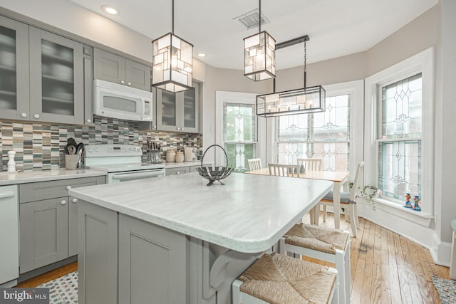 151 N Union St Unit 6, Lambertville, NJ 08530 - kitchen featuring white appliances, gray cabinets, a breakfast bar area, tasteful backsplash, and light wood finished floors
