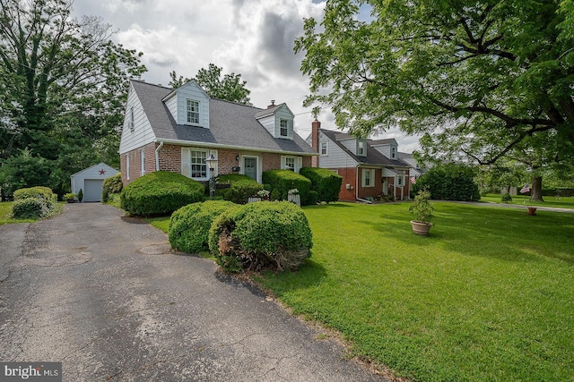 127 Long Rd, King Of Prussia, PA 19406 - cape cod-style house with brick siding, an outdoor structure, driveway, a detached garage, and a front lawn