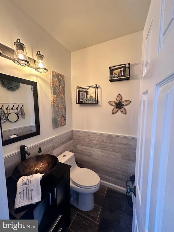 33 Aspen Ct, Bordentown, NJ 08505 - half bath featuring tile walls, a wainscoted wall, vanity, and tile patterned floors