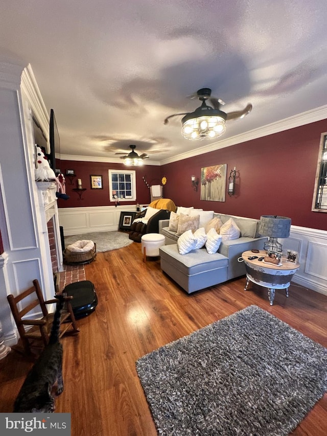 33 Aspen Ct, Bordentown, NJ 08505 - living area featuring a ceiling fan, a fireplace, wood finished floors, a wainscoted wall, and ornamental molding