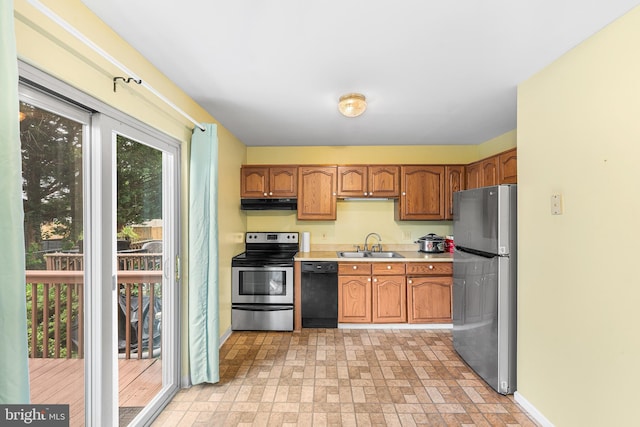 166 Center St Unit 166, Hanover, PA 17331 - kitchen featuring appliances with stainless steel finishes, light countertops, under cabinet range hood, brown cabinetry, and brick patterned floors