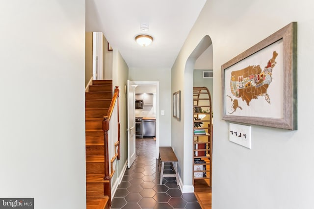 3909 17th St NE, Washington, DC 20018 - hallway with arched walkways, dark tile patterned flooring, and stairs