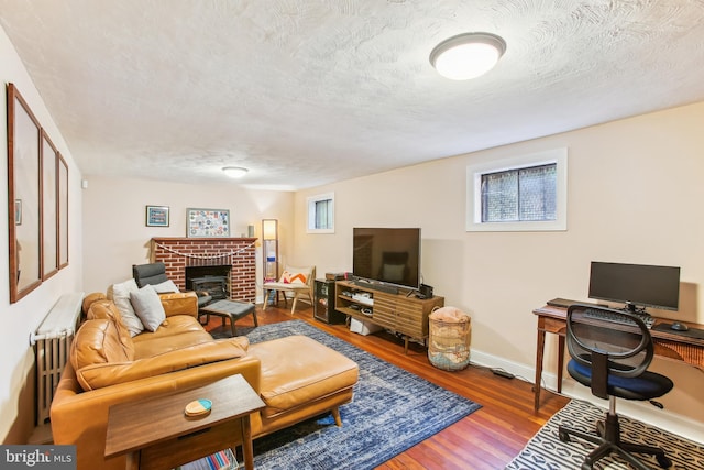 3909 17th St NE, Washington, DC 20018 - living area with a desk, a textured ceiling, a brick fireplace, wood finished floors, and plenty of natural light