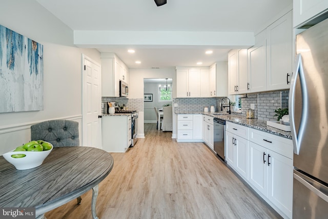 147 Meadowbrook Ave, Upper Darby, PA 19082 - kitchen featuring appliances with stainless steel finishes, light stone countertops, white cabinets, tasteful backsplash, and light wood-style floors