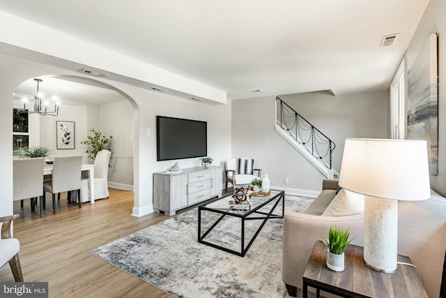 147 Meadowbrook Ave, Upper Darby, PA 19082 - living area with arched walkways, wood finished floors, a chandelier, stairs, and plenty of natural light