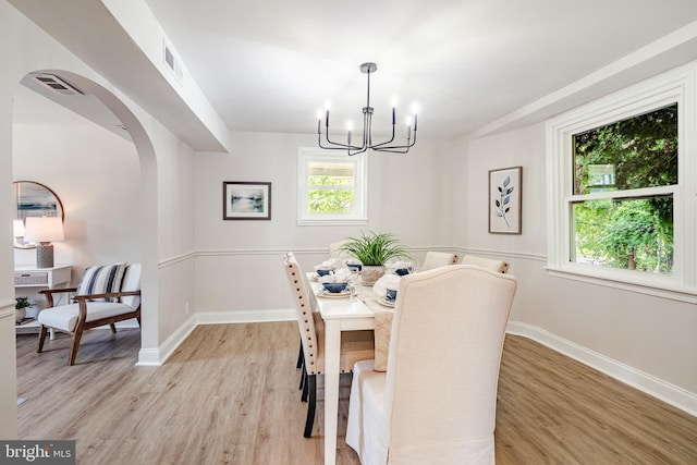 147 Meadowbrook Ave, Upper Darby, PA 19082 - dining area featuring a chandelier, light wood finished floors, and arched walkways