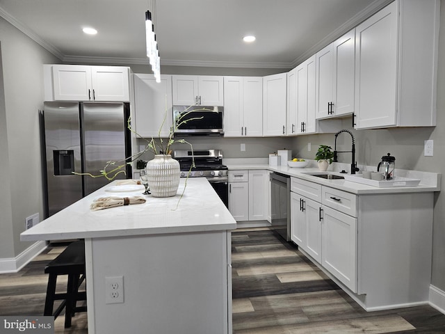 2900 Westfield Ave, Baltimore, MD 21214 - kitchen featuring stainless steel appliances, a kitchen island, dark wood-type flooring, white cabinetry, and ornamental molding