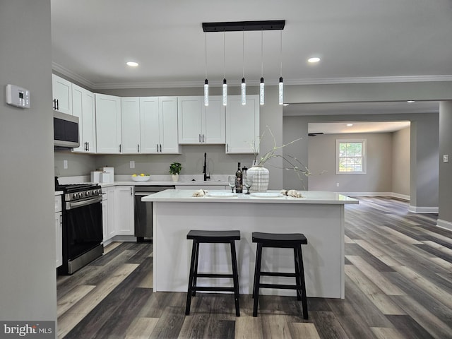 2900 Westfield Ave, Baltimore, MD 21214 - kitchen featuring appliances with stainless steel finishes, crown molding, a breakfast bar, light countertops, and white cabinets