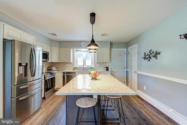 121 Pine Valley Dr, Middletown, DE 19709 - kitchen with stainless steel appliances, cream cabinets, tasteful backsplash, and wood finished floors