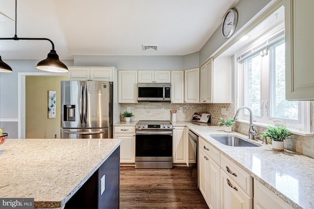 121 Pine Valley Dr, Middletown, DE 19709 - kitchen with appliances with stainless steel finishes, backsplash, light stone counters, dark wood-style flooring, and hanging light fixtures