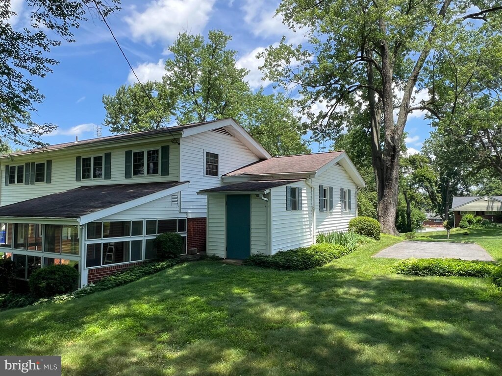 6430 Amherst Ave, Columbia, MD 21046 - back of house with a yard, roof with shingles, a sunroom, and brick siding