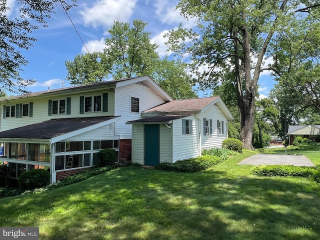 6430 Amherst Ave, Columbia, MD 21046 - back of house with a yard, roof with shingles, a sunroom, and brick siding