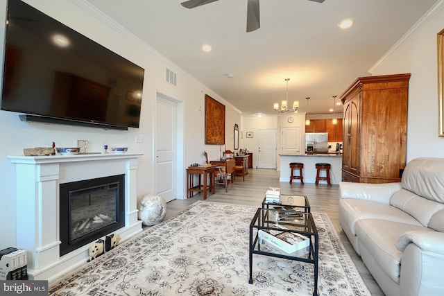 401 Bold Ruler Ct Unit 403, Havre De Grace, MD 21078 - living area with ceiling fan, a glass covered fireplace, a chandelier, crown molding, and light wood-type flooring