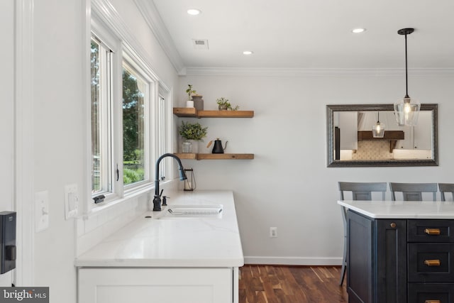 1045 Back Bay Beach Rd, West River, MD 20778 - kitchen featuring dark wood-style floors, ornamental molding, hanging light fixtures, dark cabinetry, and light stone countertops