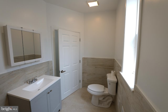 2420 N Reese St, Philadelphia, PA 19133 - half bathroom featuring tile walls, tile patterned flooring, wainscoting, and vanity