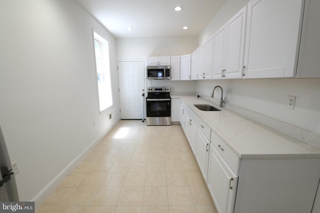 2420 N Reese St, Philadelphia, PA 19133 - kitchen with stainless steel appliances, white cabinets, recessed lighting, light stone counters, and light tile patterned floors