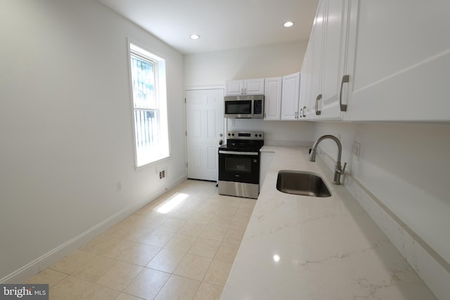 2420 N Reese St, Philadelphia, PA 19133 - kitchen featuring stainless steel appliances, light stone counters, white cabinetry, recessed lighting, and light tile patterned floors