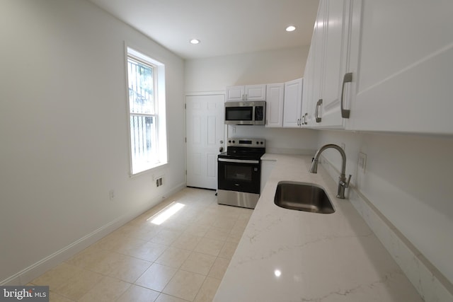 2420 N Reese St, Philadelphia, PA 19133 - kitchen with stainless steel appliances, light stone counters, white cabinetry, recessed lighting, and light tile patterned flooring