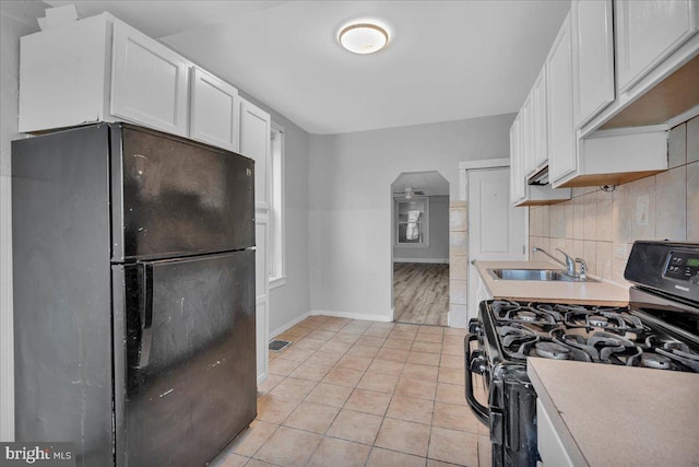 521 Bergen St, Gloucester City, NJ 08030 - kitchen featuring black appliances, arched walkways, white cabinetry, light countertops, and light tile patterned floors