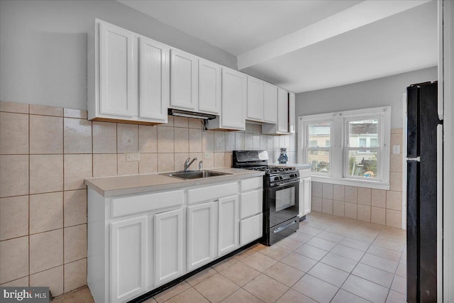 521 Bergen St, Gloucester City, NJ 08030 - kitchen with black appliances, light tile patterned floors, white cabinetry, light countertops, and tile walls