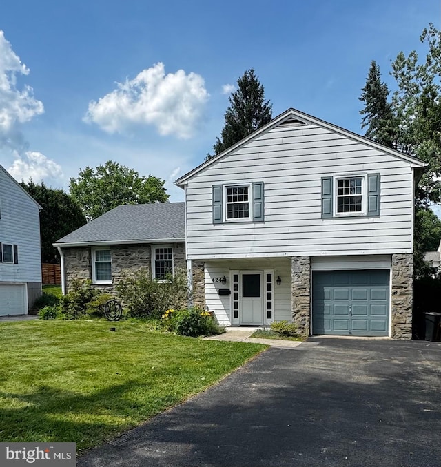 424 Foulke Ln, Springfield, PA 19064 - tri-level home featuring stone siding, an attached garage, a front lawn, and driveway