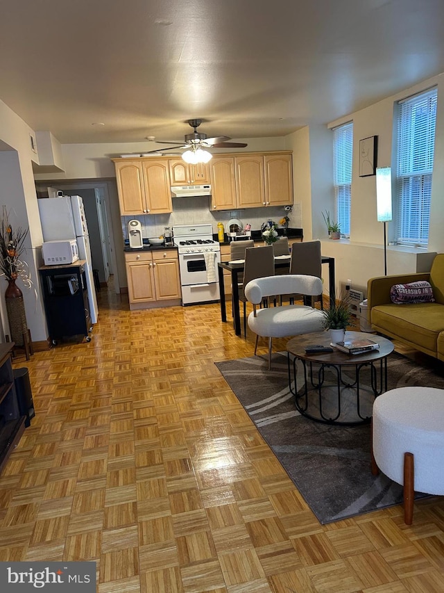 1220 Pine St, Philadelphia, PA 19107 - kitchen featuring white range with gas cooktop, light brown cabinetry, under cabinet range hood, dark countertops, and ceiling fan
