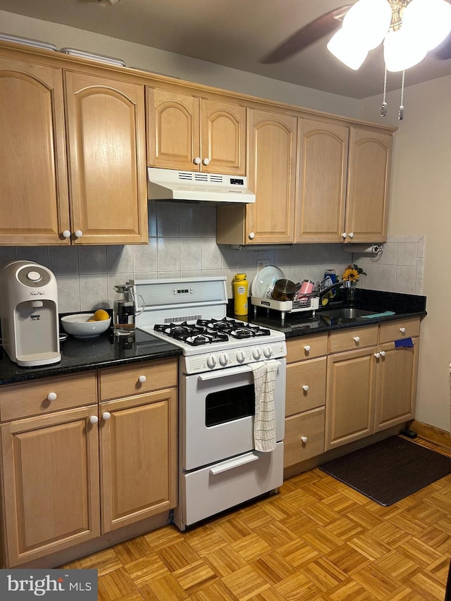1220 Pine St, Philadelphia, PA 19107 - kitchen with under cabinet range hood, white gas range oven, backsplash, light brown cabinetry, and ceiling fan