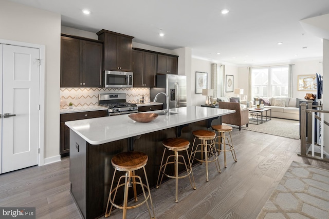 5407 Cedar Grove Drive G-Strauss, Upper Marlboro, MD 20772 - kitchen with appliances with stainless steel finishes, wood finished floors, a breakfast bar area, dark brown cabinets, and recessed lighting