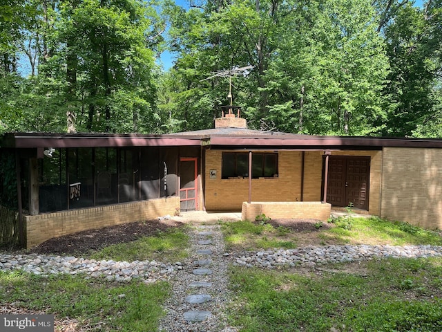 4871 Ellicott Woods Ln, Ellicott City, MD 21043 - view of front of house featuring brick siding, a chimney, and a sunroom