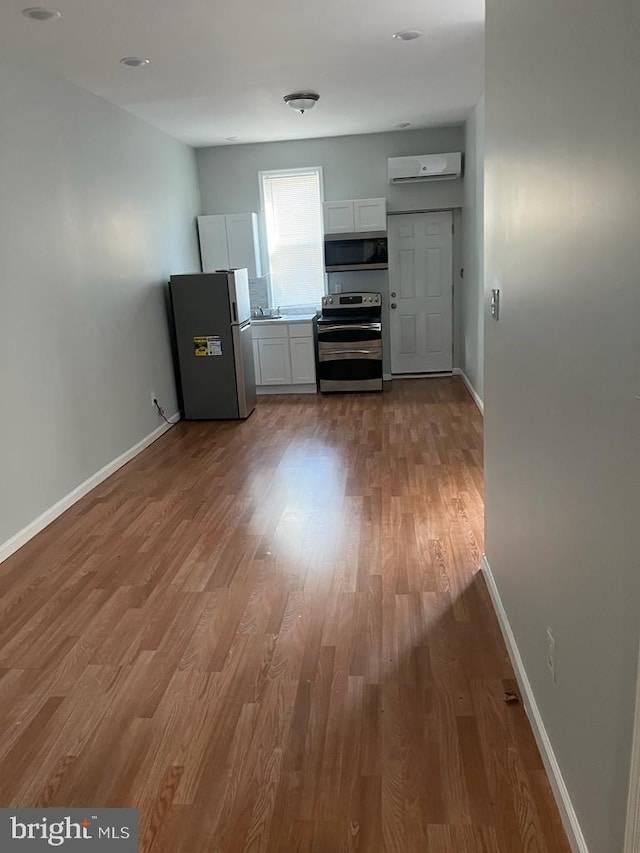 3637 N 19th St, Philadelphia, PA 19140 - unfurnished living room with wood finished floors and a wall mounted air conditioner