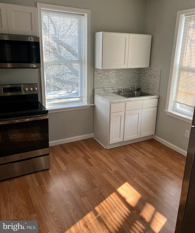 3637 N 19th St, Philadelphia, PA 19140 - kitchen featuring stainless steel appliances, light countertops, light wood-style flooring, and plenty of natural light